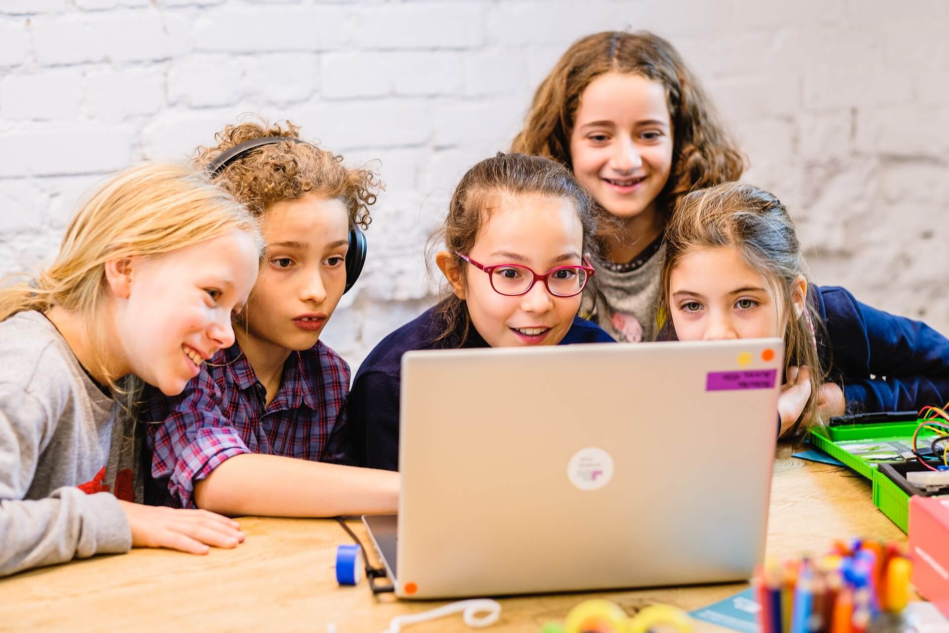 Im TüftelLab digital lernen Kinder begeistert neue digitale Tools kennen von zu Hause vor einem Laptop.
