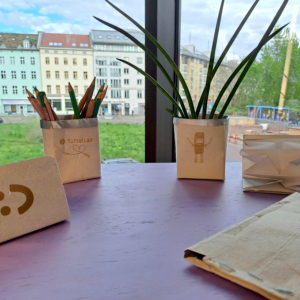Verschiedene Kreationen mit Tetrapaks: ein Blumentopf, ein Federmäppchen und Pflanzendrucke.