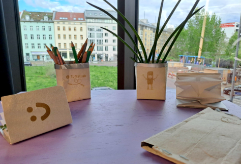 Verschiedene Kreationen mit Tetrapaks: ein Blumentopf, ein Federmäppchen und Pflanzendrucke.
