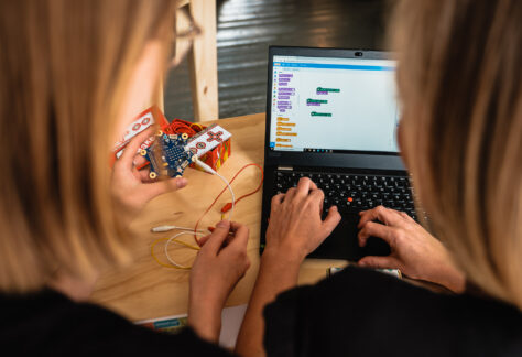 2 Personen Sitzen An Einem Laptop Und Schauen Sich Das Programiertool &Amp;Quot;Scratch&Amp;Quot; An.